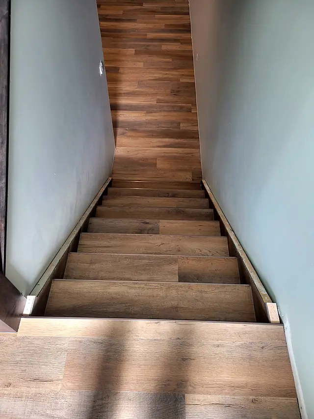 Narrow staircase finished in wood-look plank flooring