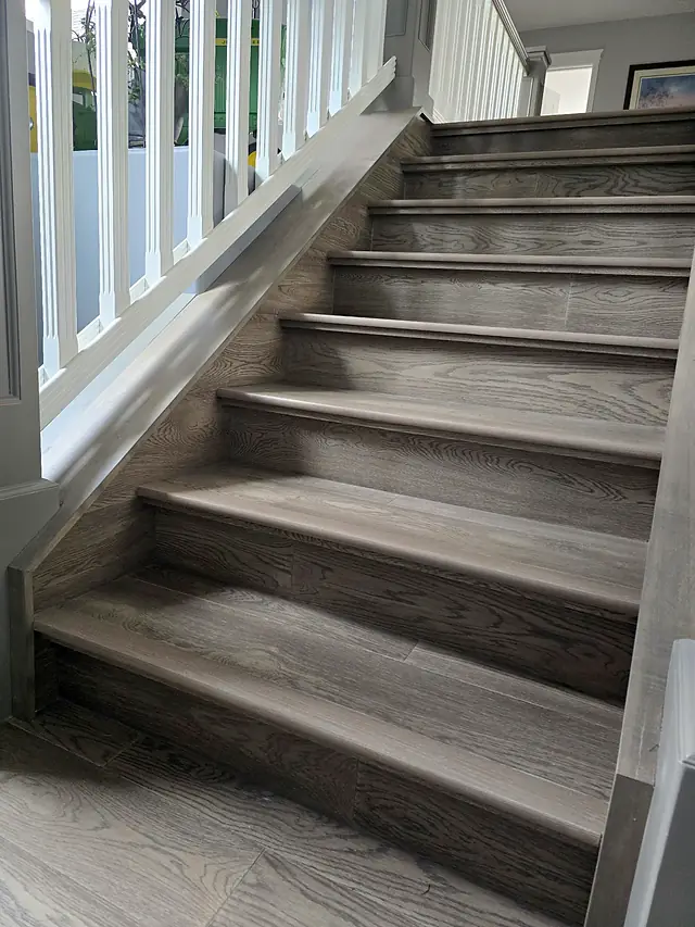 Gray-stained wood stair treads with matching flooring