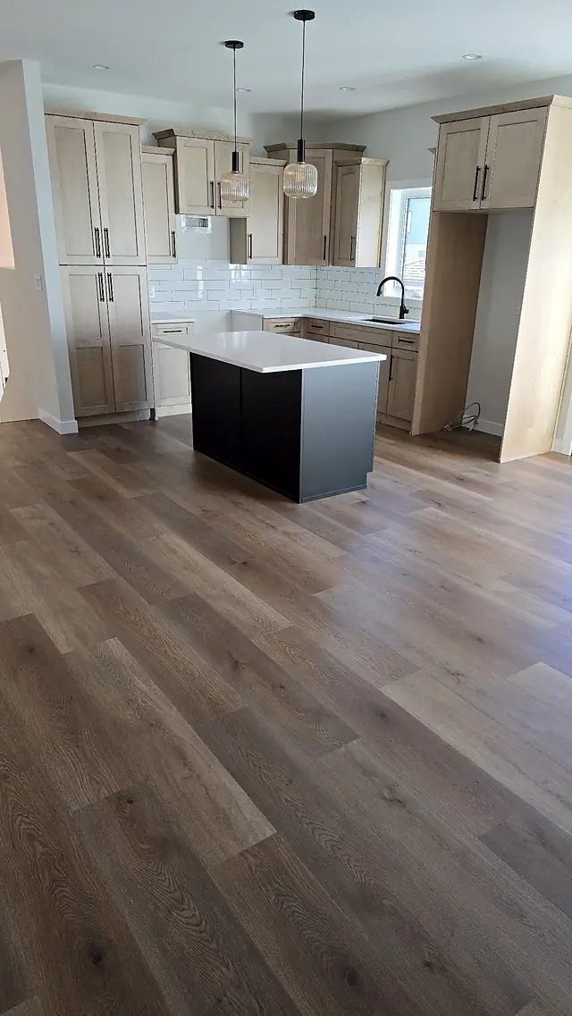 Bright kitchen with an island and light oak-look plank flooring